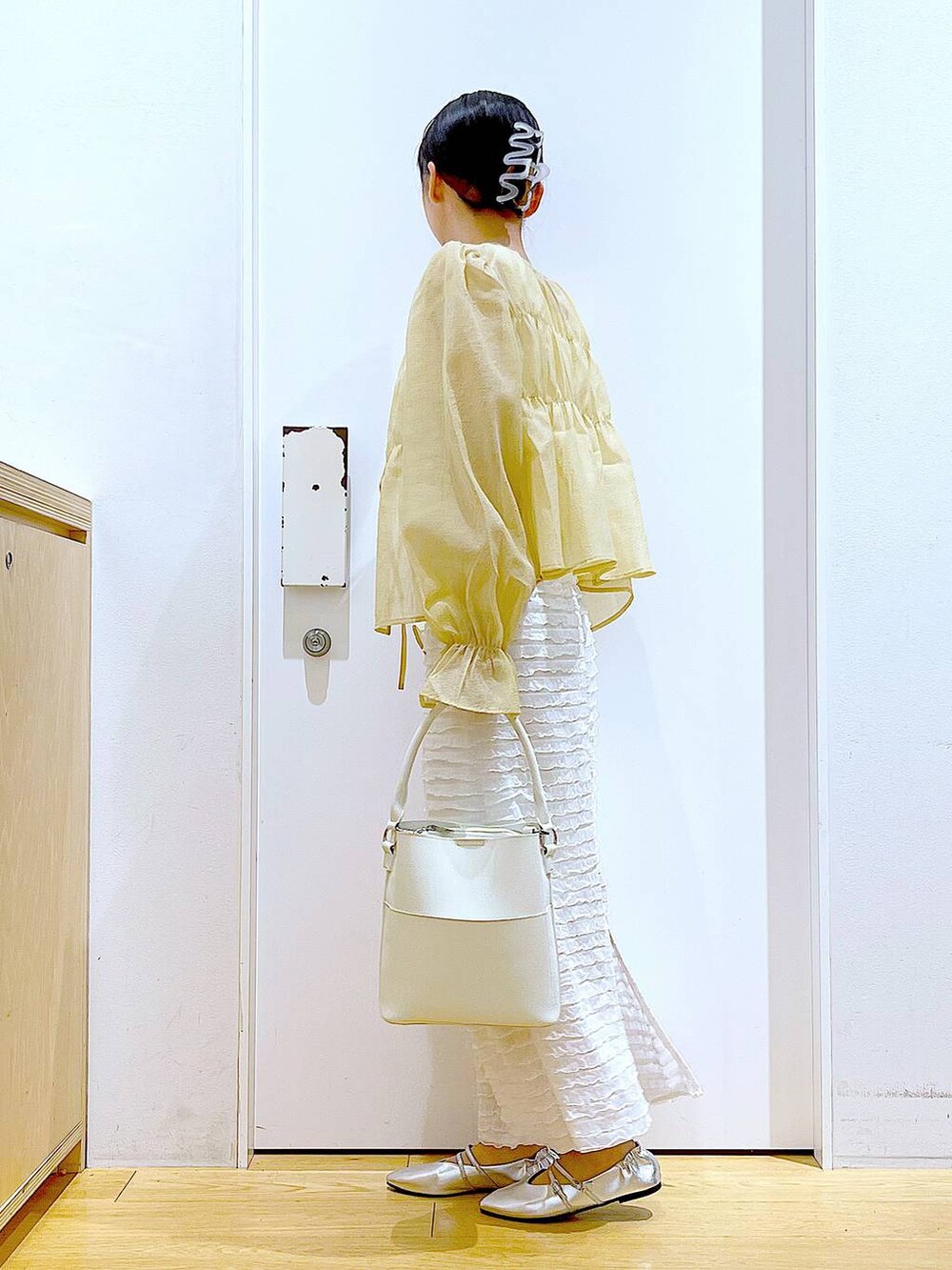 ホワイト系のベスト、ホワイト系のショルダーバッグ、ホワイト系のスカートを着用したレディースの秋コーディネートの3枚目の写真