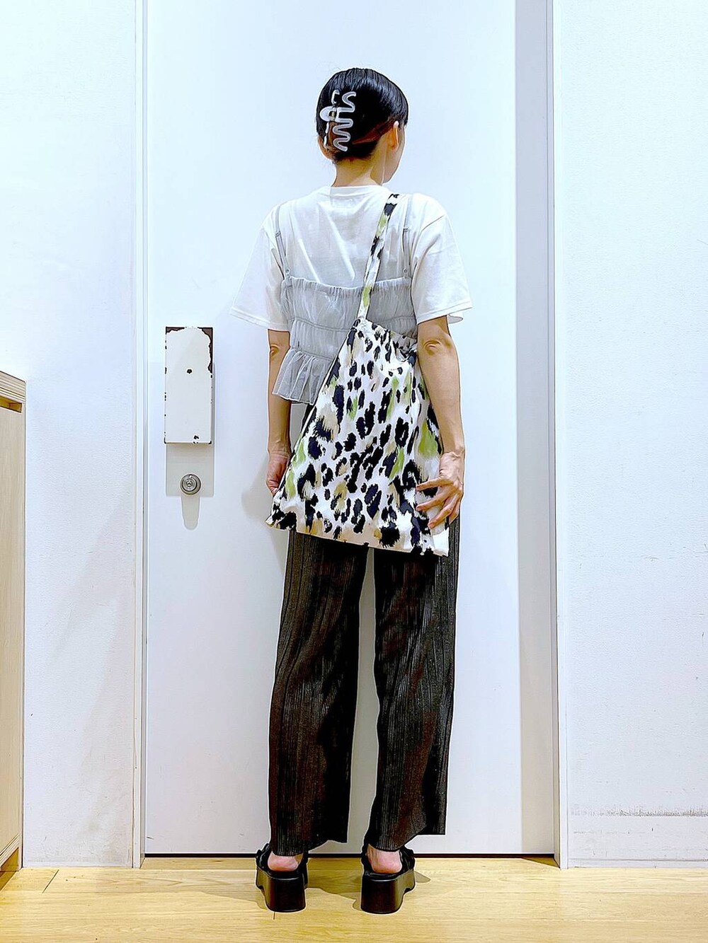 グリーン系のトートバッグ、シルバー系のキャミソール、ホワイト系のTシャツ/カットソーを着用したレディースの夏コーディネートの5枚目の写真