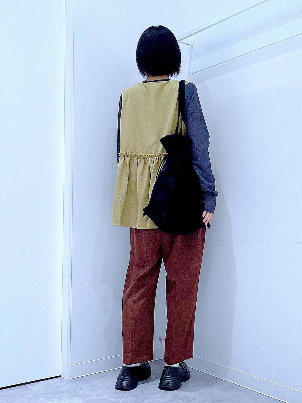 グレー系のTシャツ/カットソー、ブラック系のローファー、ブラック系のトートバッグを着用したレディースの秋コーディネートの5枚目の写真