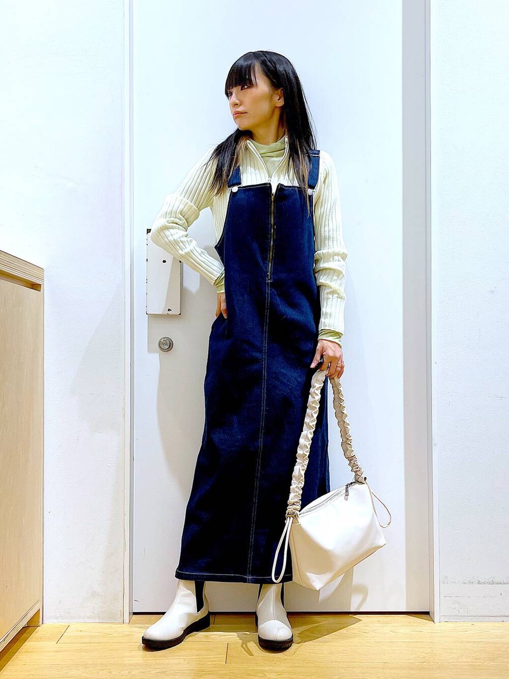 ブルー系のジャンパースカート、ベージュ系のカーディガン/ボレロ、グリーン系のその他トップスを着用したレディースの春コーディネートの2枚目の写真