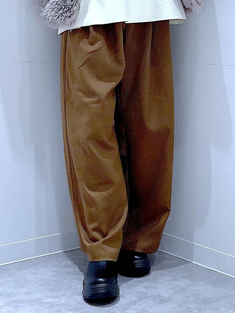 グレー系のベスト、ホワイト系のショルダーバッグ、ブラック系のブーツを着用したレディースの冬コーディネートの8枚目の写真