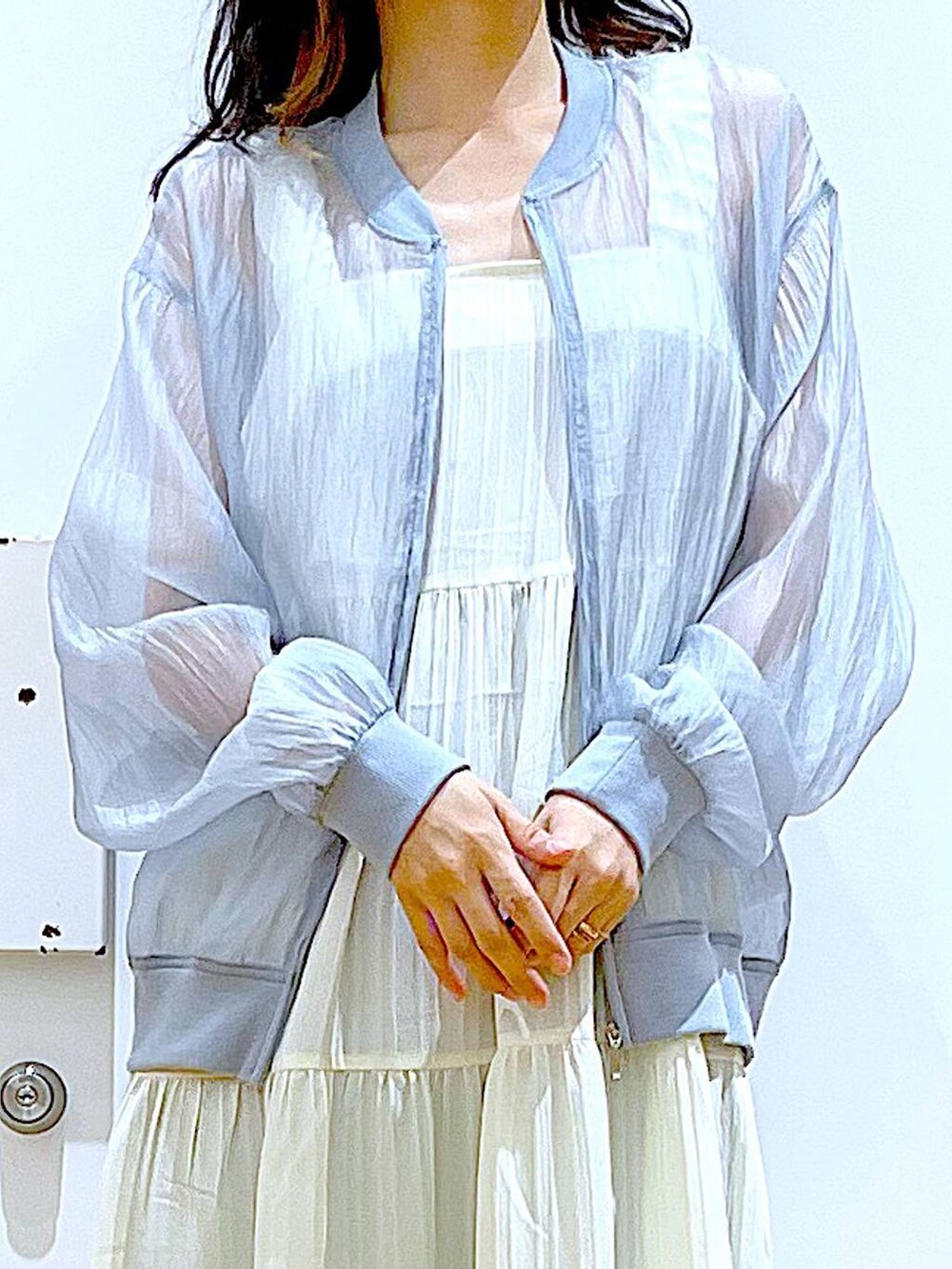 ブルー系のデニムパンツ、シルバー系のトートバッグ、シルバー系のサンダルを着用したレディースの夏コーディネートの7枚目の写真