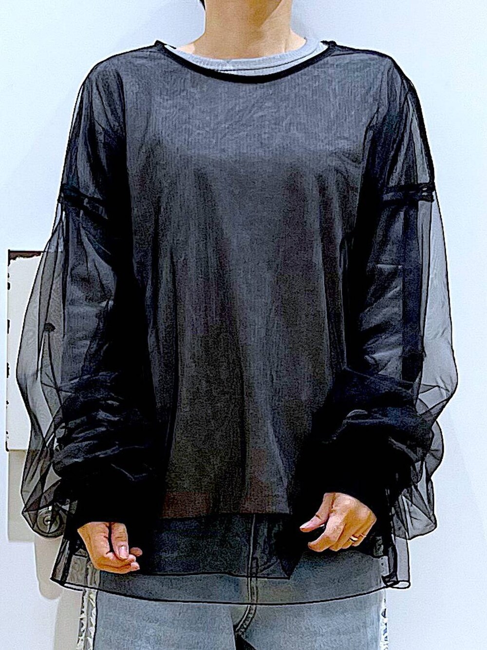 ブラック系のスニーカー、ブラック系のショルダーバッグ、ブルー系のデニムパンツを着用したレディースの春コーディネートの7枚目の写真