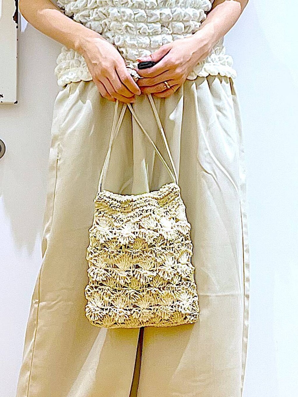 シルバー系のサンダル、ベージュ系のショルダーバッグ、ベージュ系のTシャツ/カットソーを着用したレディースの夏コーディネートの9枚目の写真