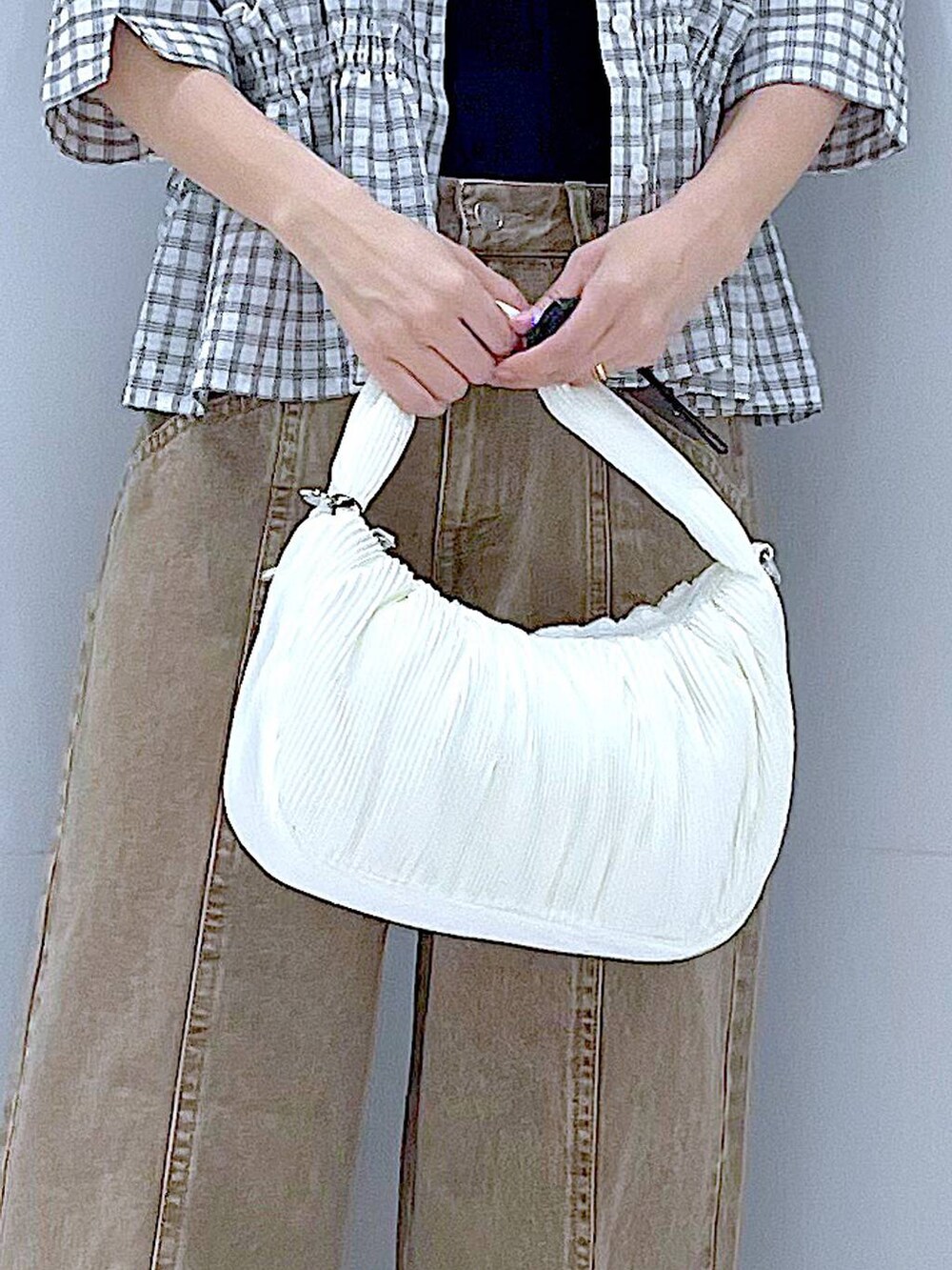 ホワイト系のサンダル、ホワイト系のショルダーバッグ、ベージュ系のデニムパンツを着用したレディースの夏コーディネートの9枚目の写真