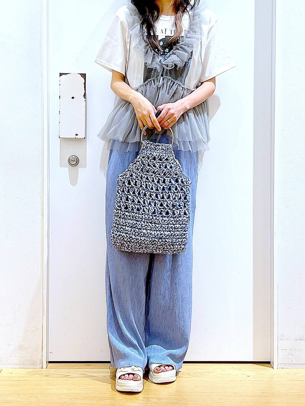 ホワイト系のサンダル、ブルー系のハンドバッグ、ブルー系のその他パンツを着用したレディースの夏コーディネートの6枚目の写真