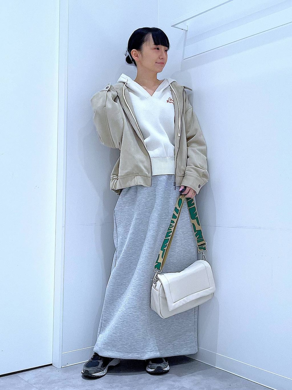 ホワイト系のショルダーバッグ、ベージュ系のニット/セーター、グレー系のスカートを着用したレディースの春コーディネートの2枚目の写真