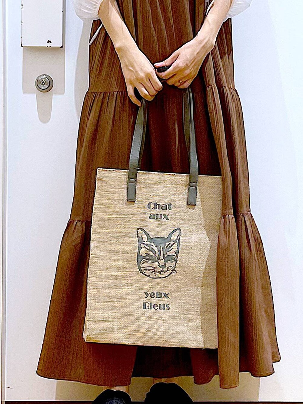 ブラック系のサンダル、ベージュ系のワンピース、グレー系のトートバッグを着用したレディースの夏コーディネートの9枚目の写真