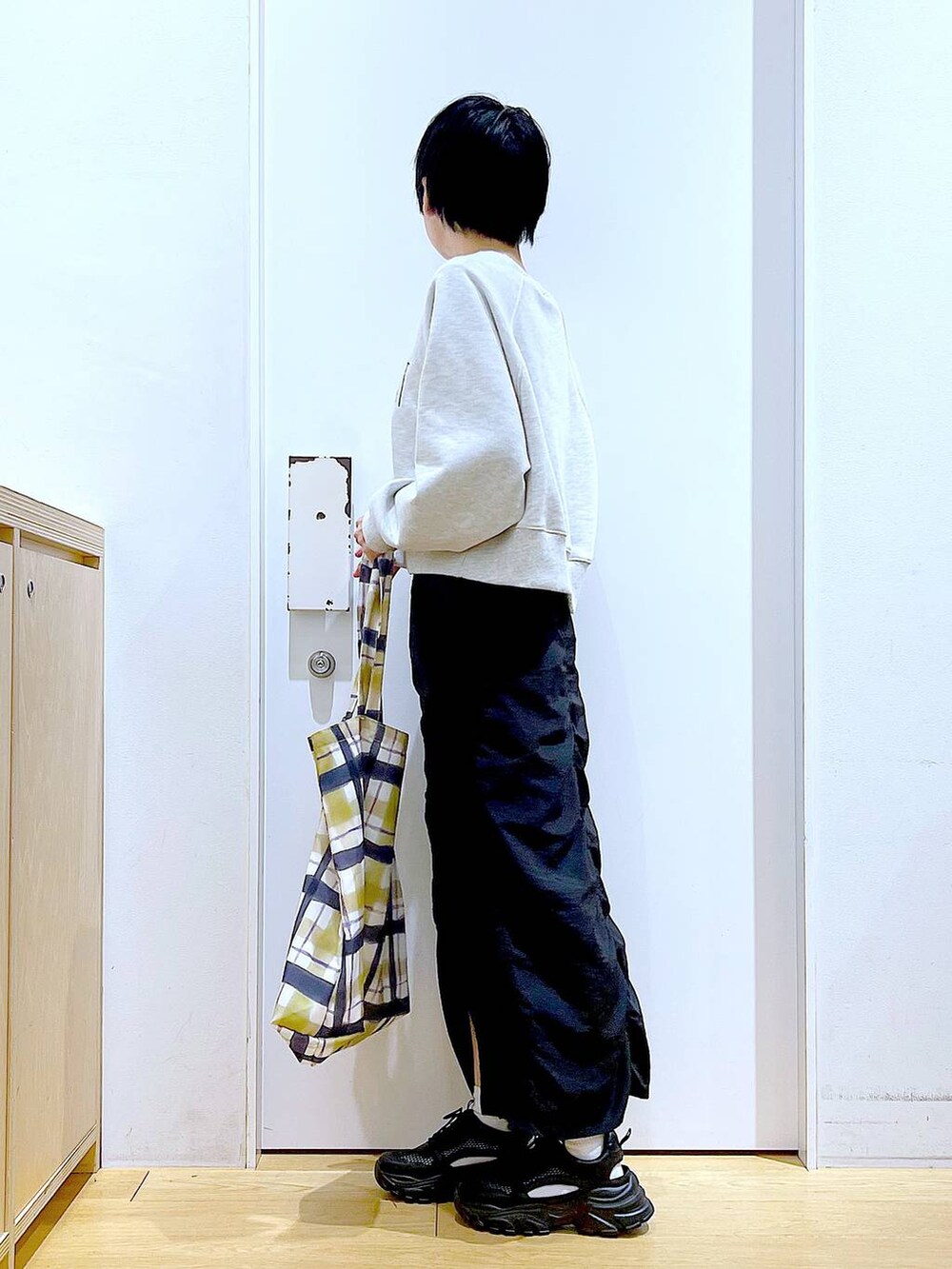 ブラック系のスカート、ブラック系のスニーカー、その他のトートバッグを着用したレディースの春コーディネートの3枚目の写真