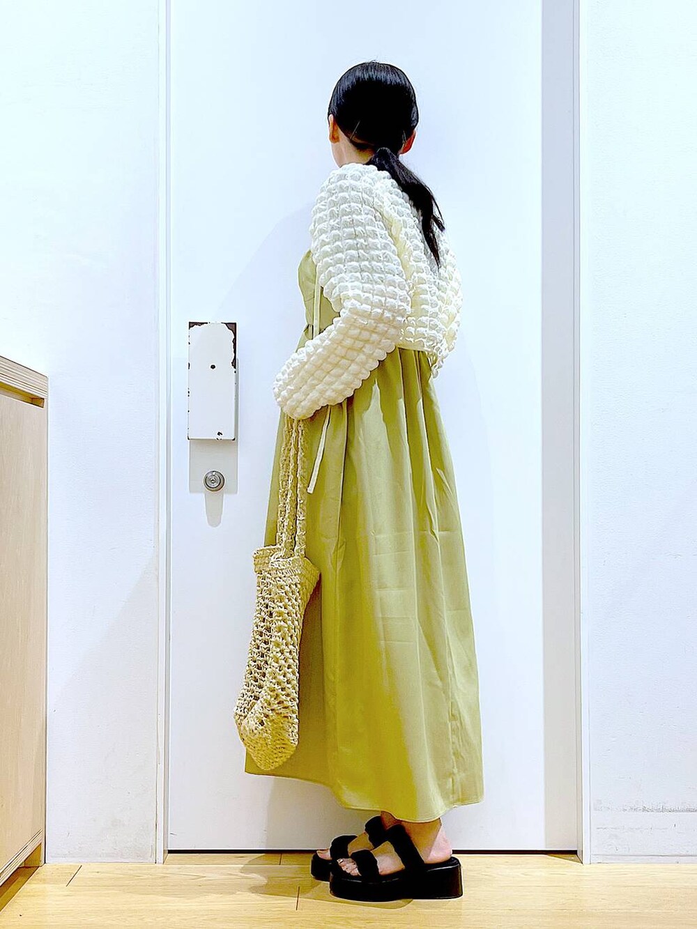 ブラック系のサンダル、ホワイト系のトートバッグ、ベージュ系のカーディガン/ボレロを着用したレディースの夏コーディネートの3枚目の写真