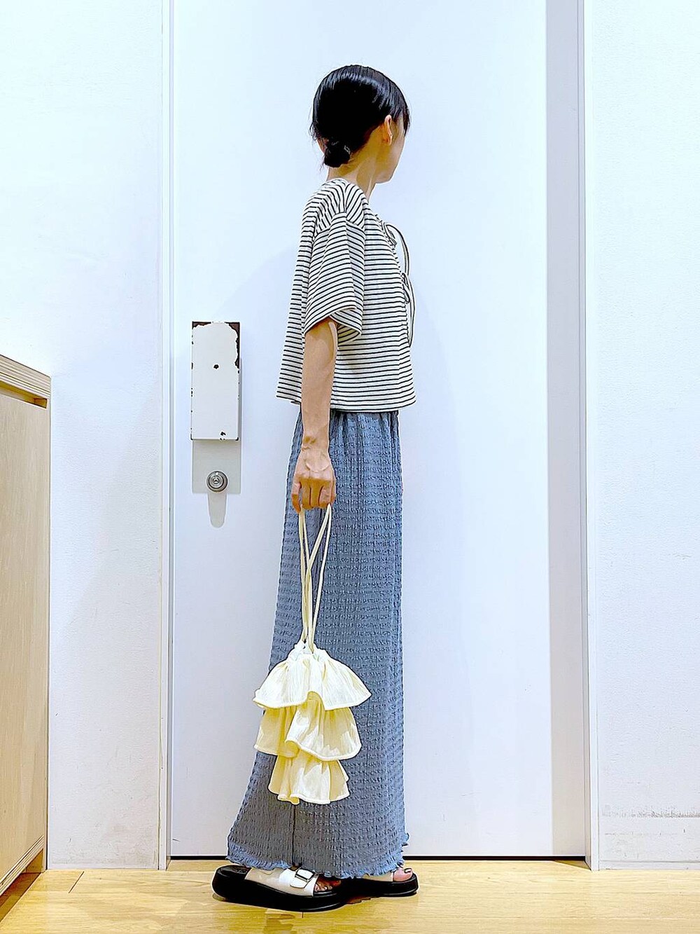 ホワイト系のサンダル、ブルー系のスカート、ホワイト系のショルダーバッグを着用したレディースの秋コーディネートの4枚目の写真