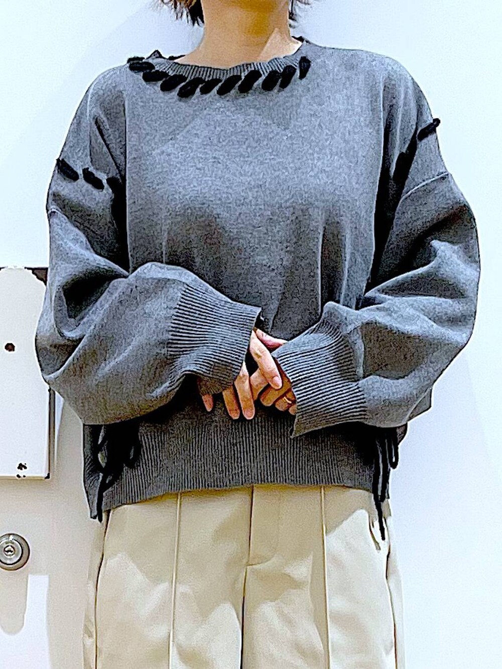 ブラック系のトートバッグ、ブラック系のブーツ、グレー系のニット/セーターを着用したレディースの冬コーディネートの7枚目の写真