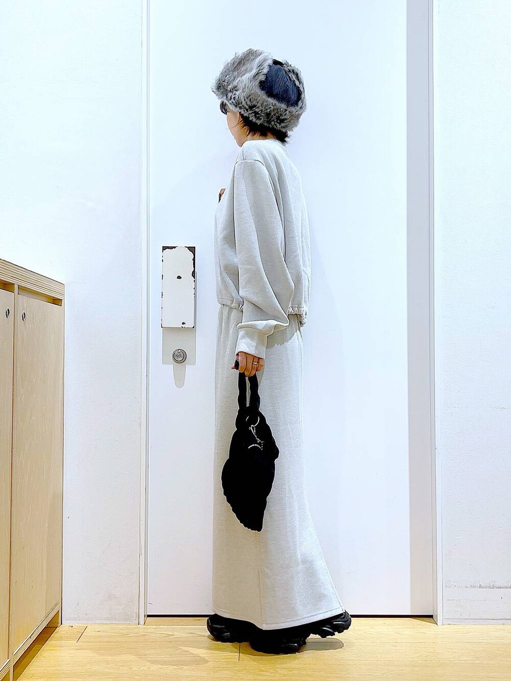 ブラック系のブーツ、ブラック系のショルダーバッグ、ベージュ系のスウェットを着用したレディースの冬コーディネートの3枚目の写真