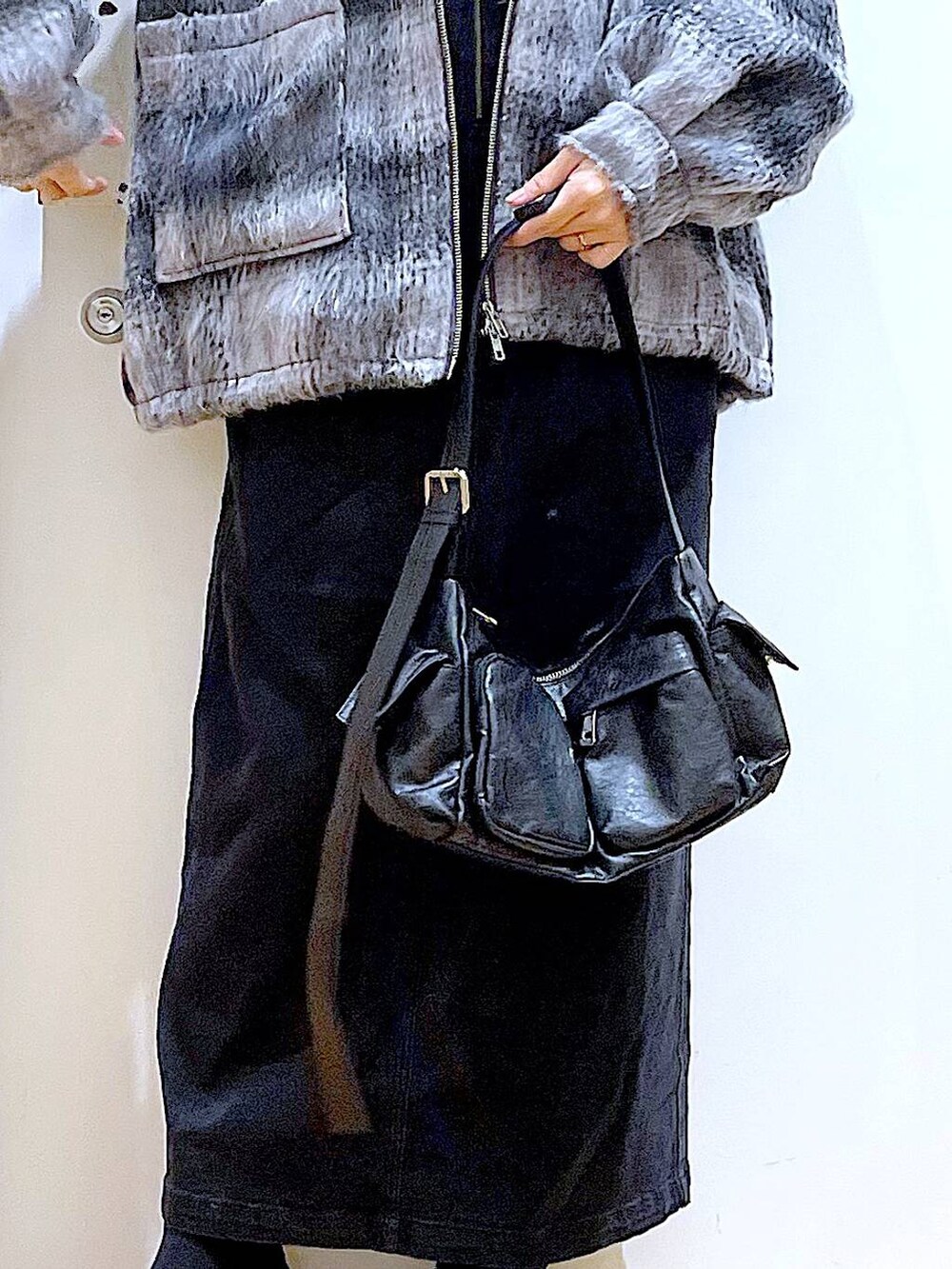 グレー系のジャンパースカート、ブラック系のブーツ、ブラック系のショルダーバッグを着用したレディースの冬コーディネートの9枚目の写真