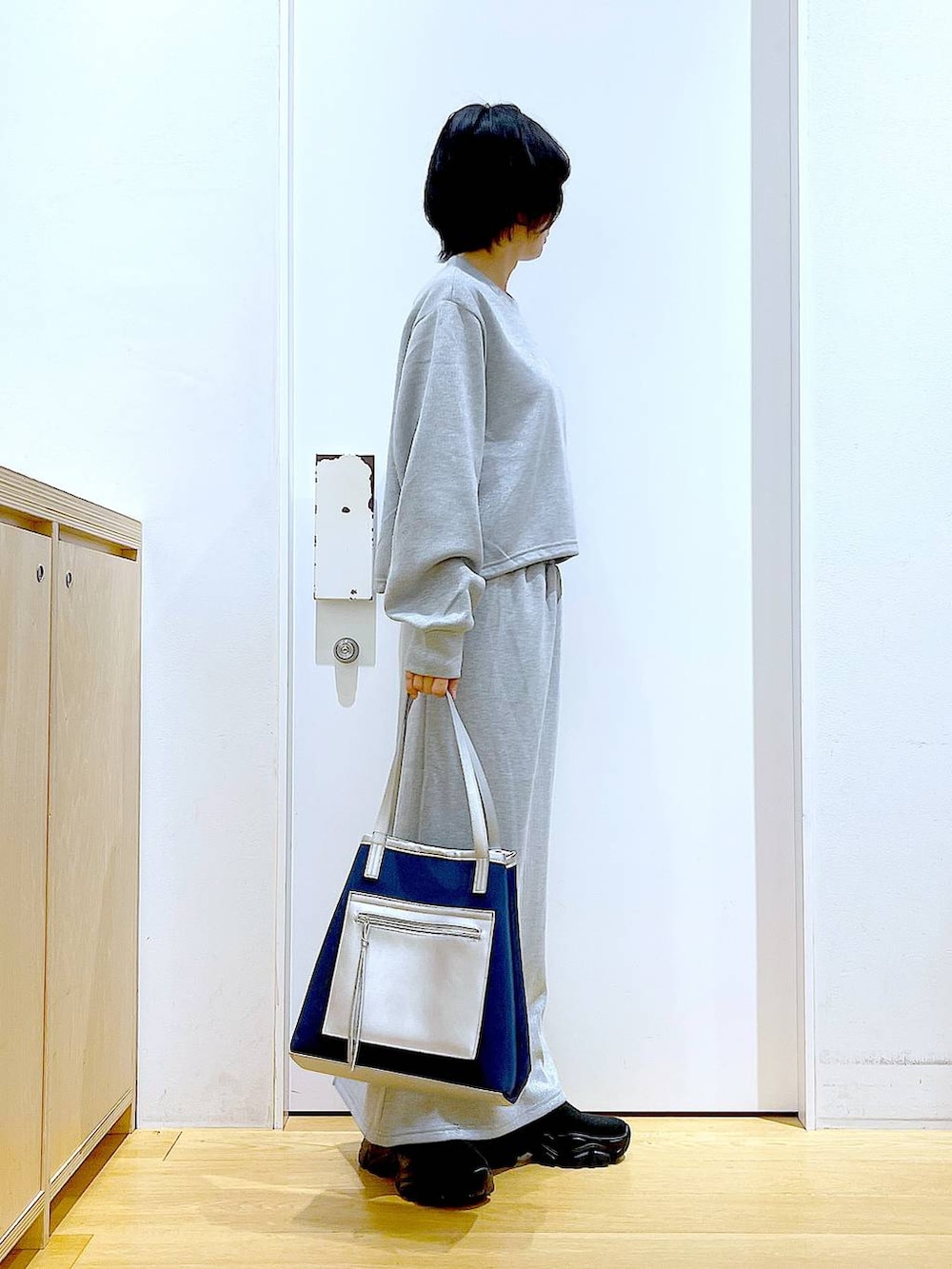 ブラック系のブーツ、ブルー系のトートバッグ、グレー系のスウェットを着用したレディースの冬コーディネートの4枚目の写真