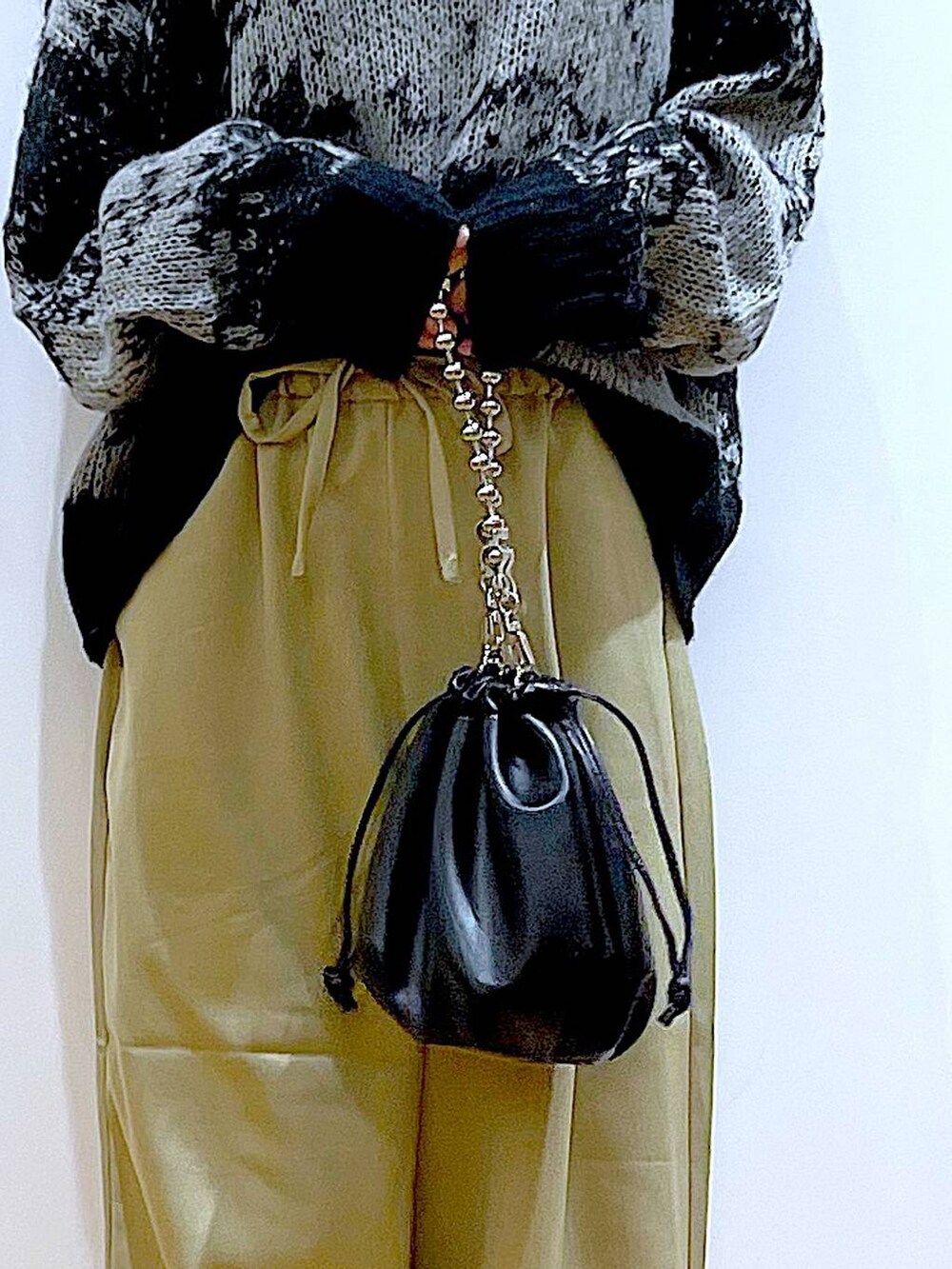 ブラック系のショルダーバッグ、ブラック系のブーツ、イエロー系のその他パンツを着用したレディースの冬コーディネートの9枚目の写真