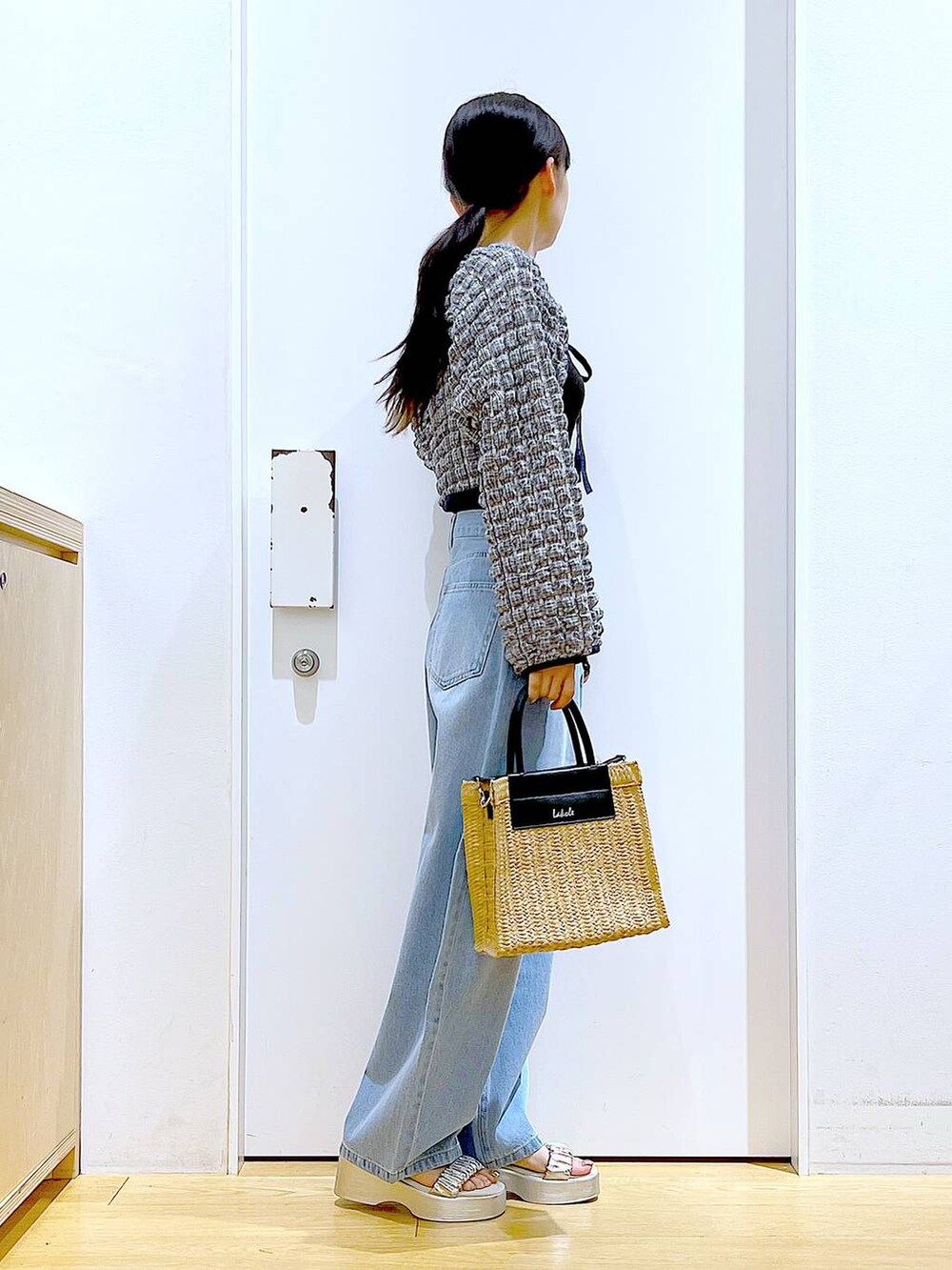 ブルー系のデニムパンツ、ブラック系のTシャツ/カットソー、ベージュ系のショルダーバッグを着用したレディースの夏コーディネートの4枚目の写真