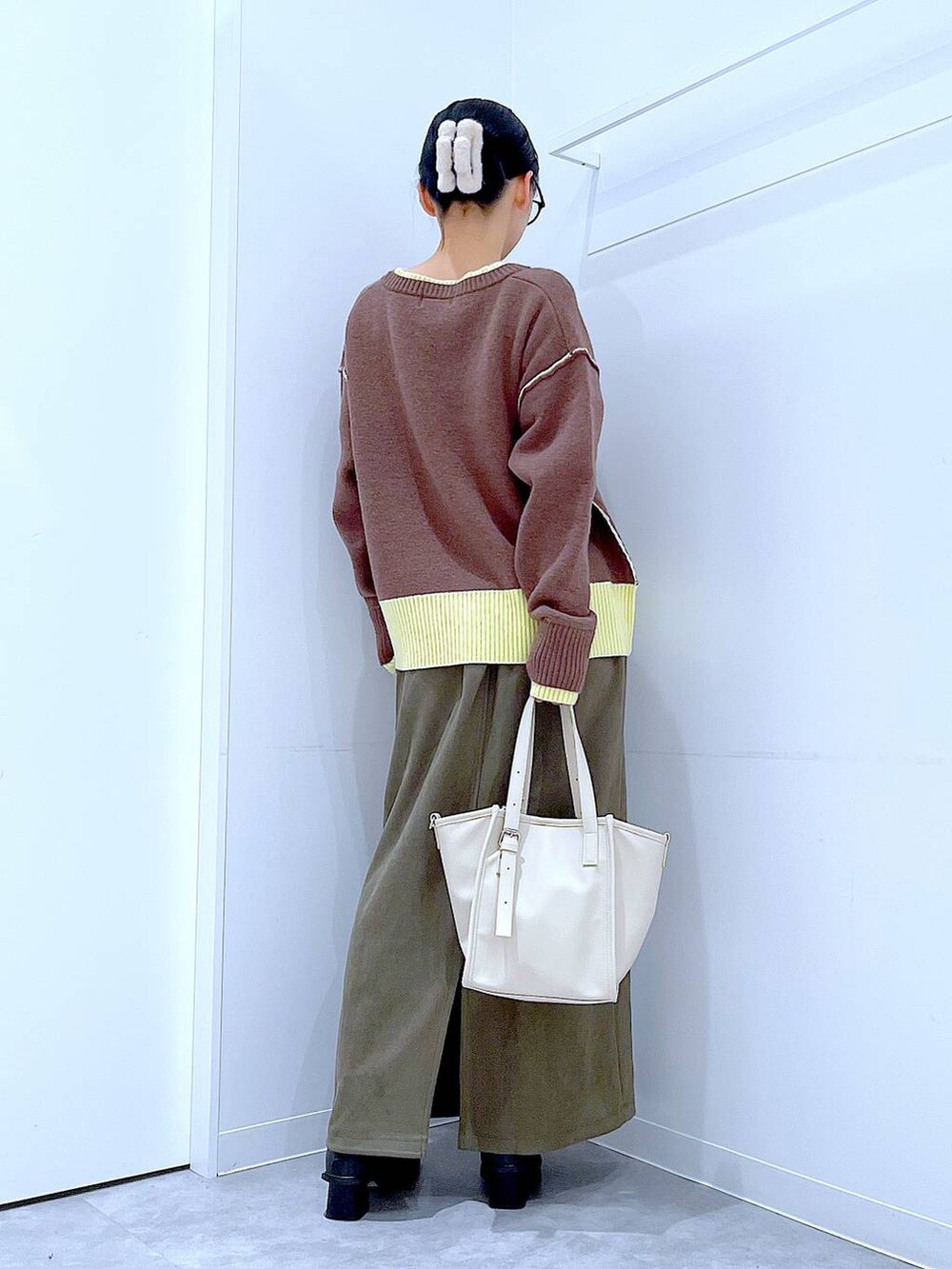 ブラック系のブーツ、グリーン系のスカート、ホワイト系のトートバッグを着用したレディースの冬コーディネートの5枚目の写真