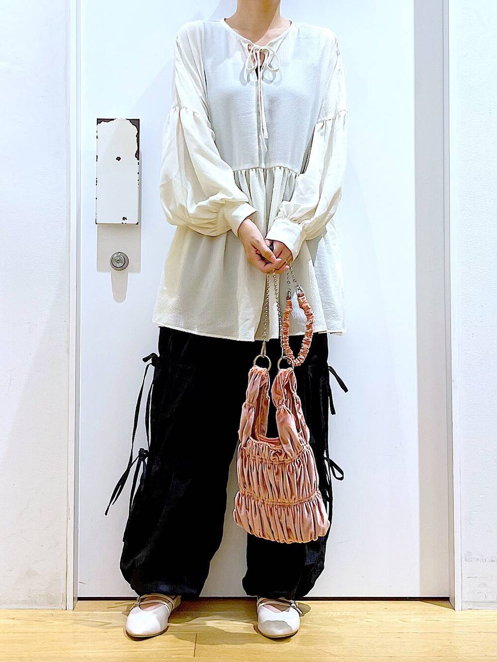 ホワイト系のパンプス、ブラック系のその他パンツ、ホワイト系のチュニックを着用したレディースの秋コーディネートの6枚目の写真