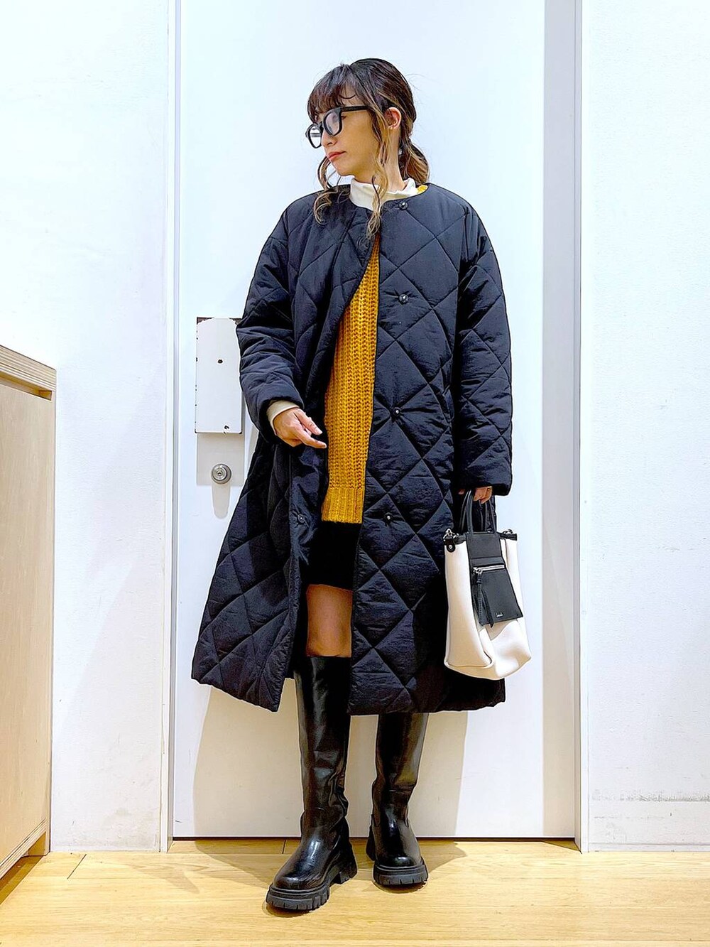 ブラック系のブーツ、ベージュ系のTシャツ/カットソー、ブラック系のその他パンツを着用したレディースの冬コーディネートの2枚目の写真