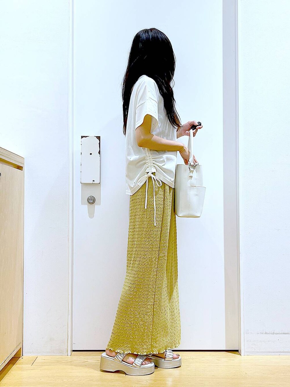 シルバー系のサンダル、ホワイト系のショルダーバッグ、グリーン系のスカートを着用したレディースの夏コーディネートの4枚目の写真