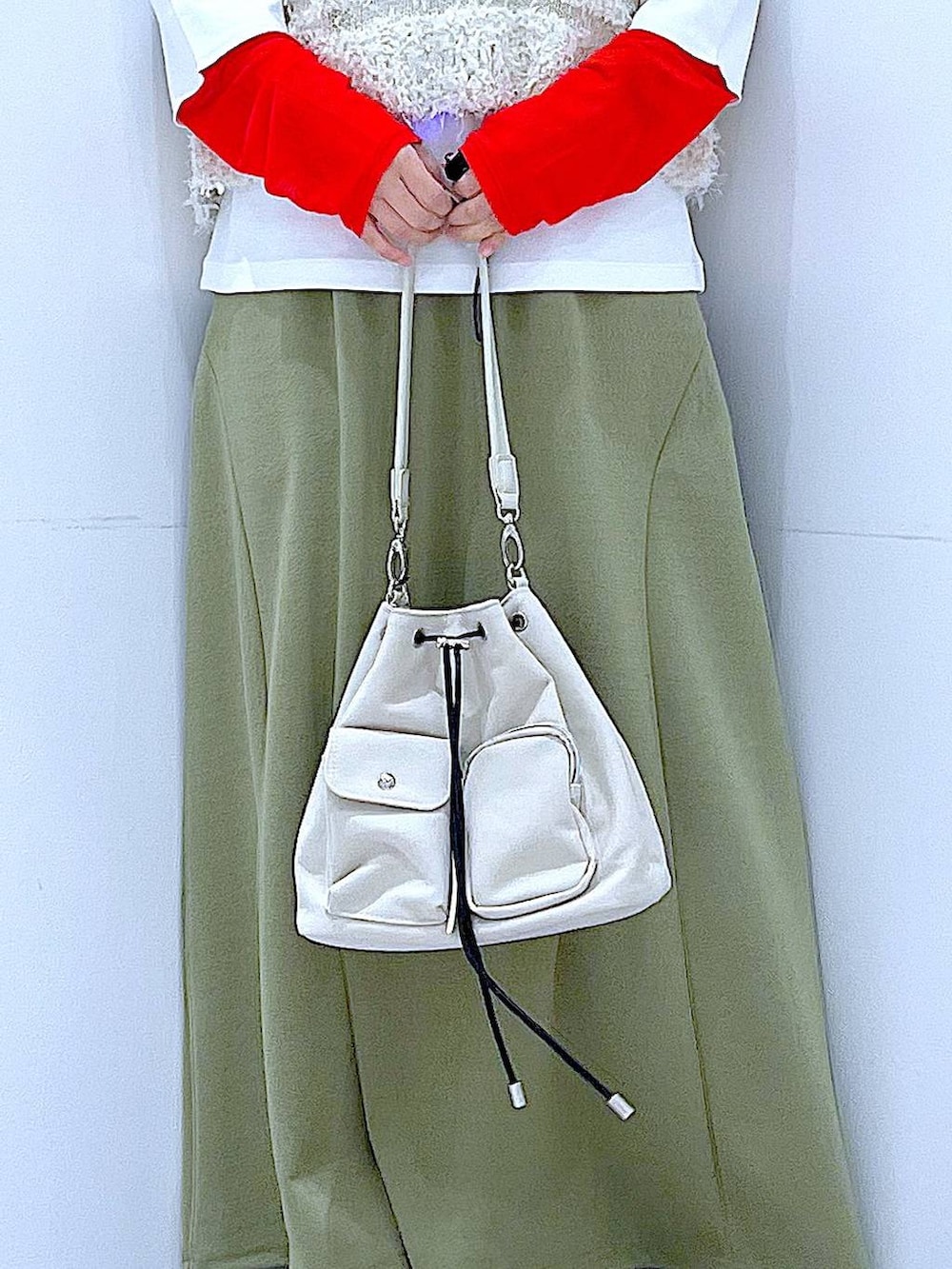 グリーン系のスカート、ホワイト系のTシャツ/カットソー、ベージュ系のベストを着用したレディースの冬コーディネートの9枚目の写真