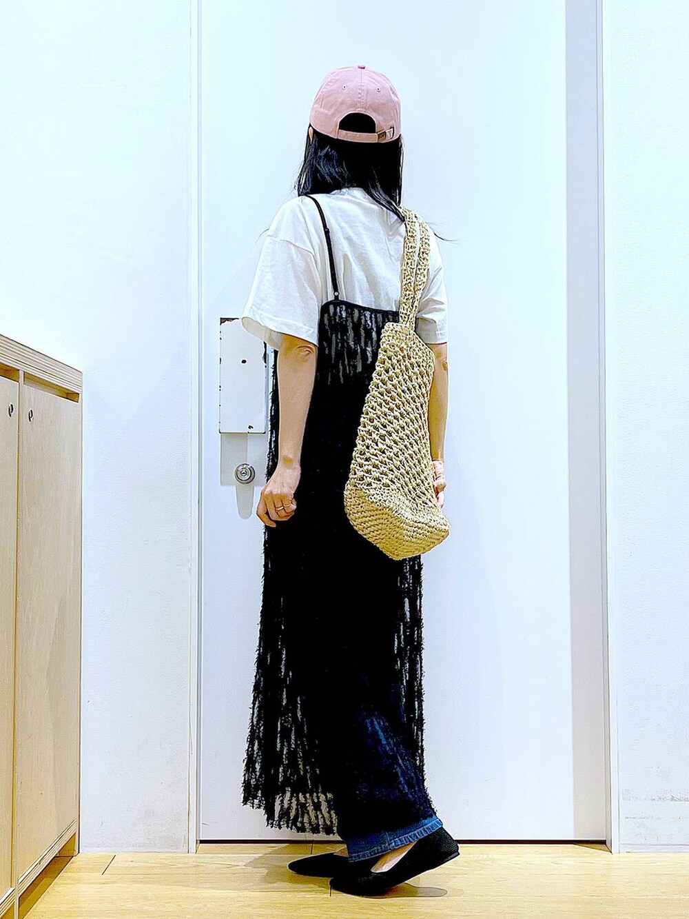 ブルー系のデニムパンツ、ブラック系のワンピース、ブラック系のパンプスを着用したレディースの春コーディネートの3枚目の写真