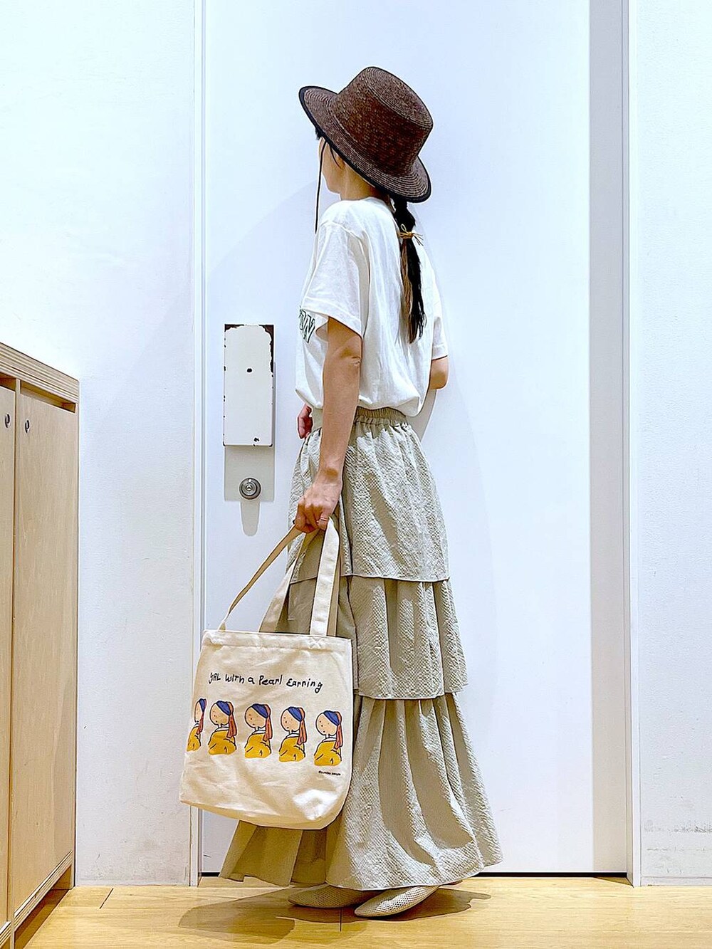 ベージュ系のスカート、ホワイト系のTシャツ/カットソー、その他のトートバッグを着用したレディースの春コーディネートの3枚目の写真