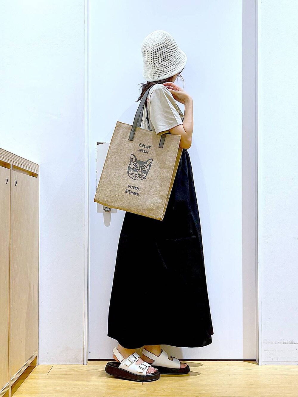 ホワイト系のサンダル、グレー系のトートバッグ、ブラック系のワンピースを着用したレディースの夏コーディネートの4枚目の写真