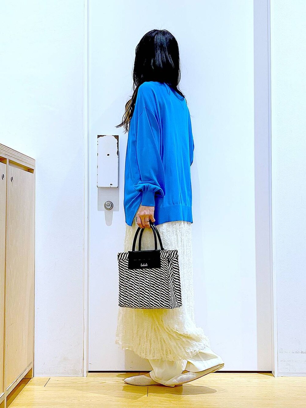 ホワイト系のその他パンツ、ブルー系のカーディガン/ボレロ、ホワイト系のパンプスを着用したレディースの春コーディネートの3枚目の写真