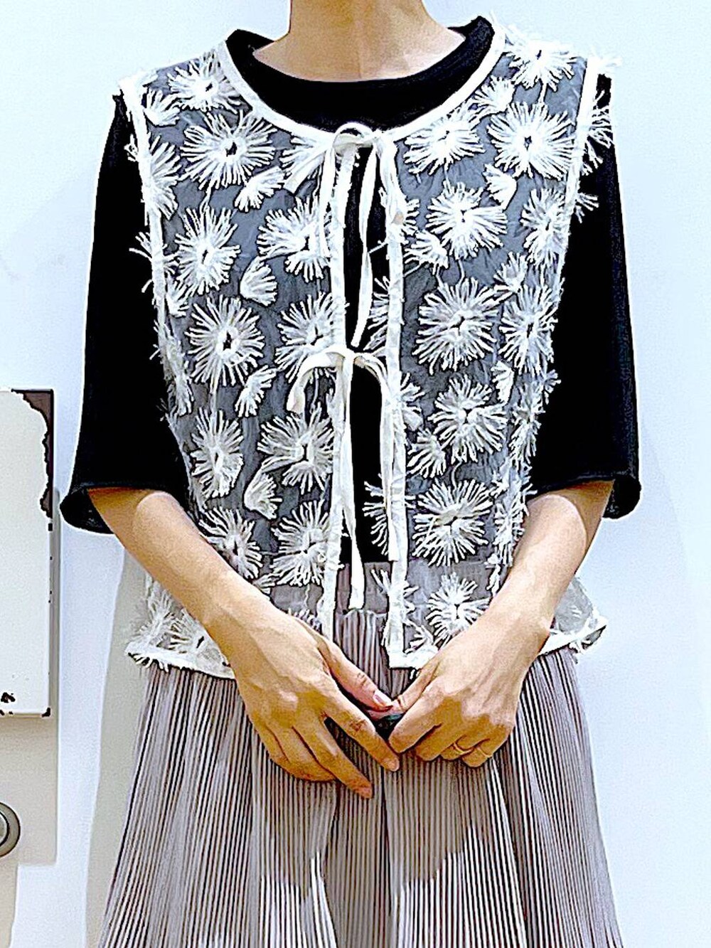 グレー系のスカート、ブラック系のサンダル、ホワイト系のショルダーバッグを着用したレディースの夏コーディネートの7枚目の写真