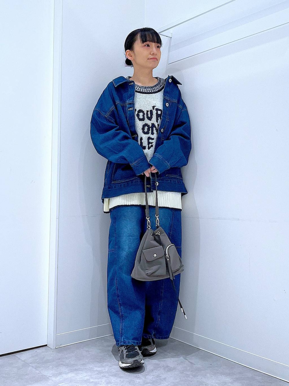 ブルー系のデニムジャケット、ホワイト系のニット/セーター、ブルー系のデニムパンツを着用したレディースの冬コーディネートの2枚目の写真