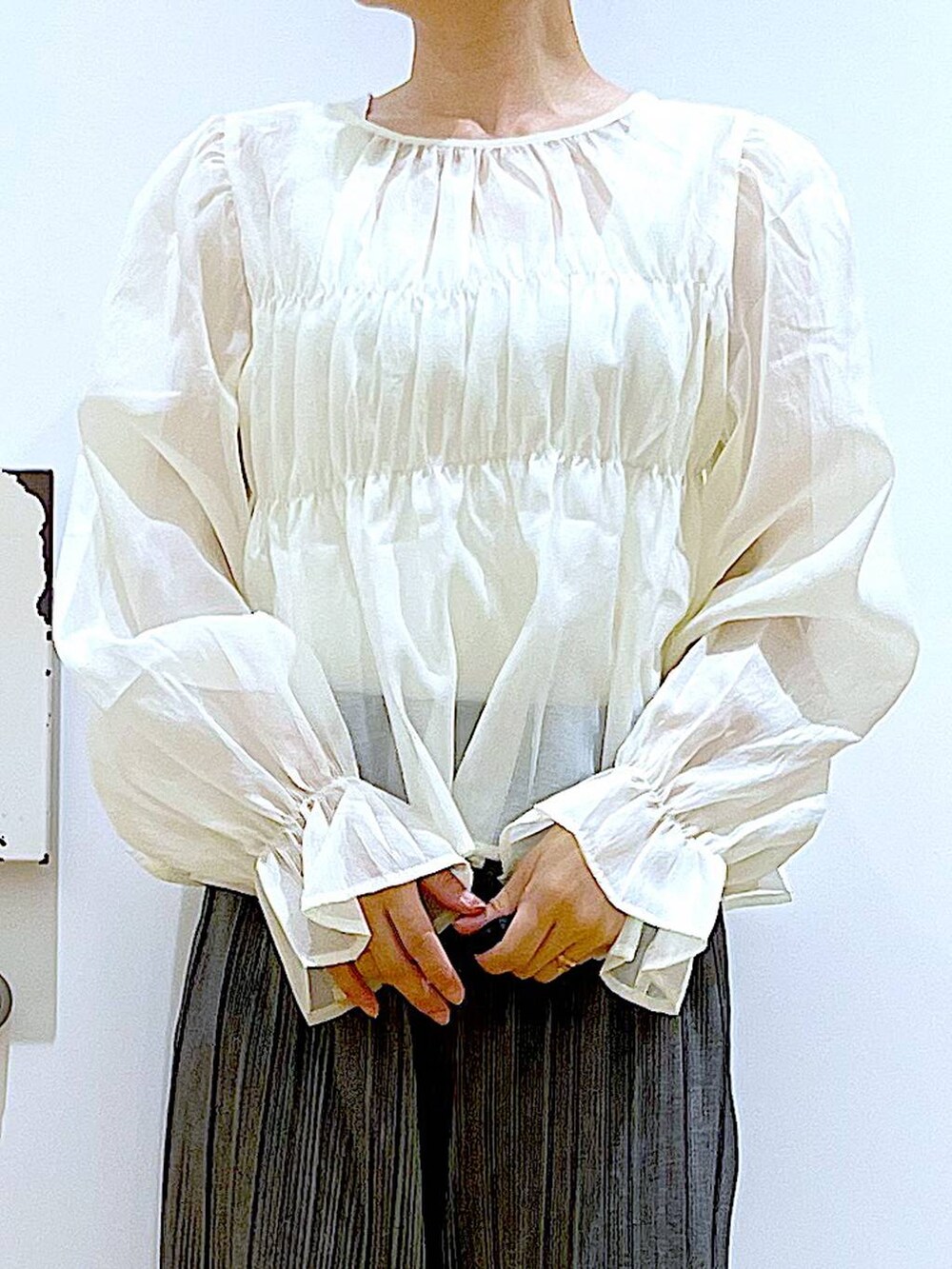 グレー系のその他パンツ、ブラック系のパンプス、ホワイト系のシャツ/ブラウスを着用したレディースの秋コーディネートの7枚目の写真