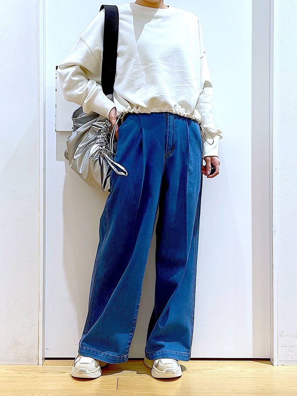 ホワイト系のスウェット、ブルー系のデニムパンツ、ベージュ系のスニーカーを着用したレディースの冬コーディネートの6枚目の写真