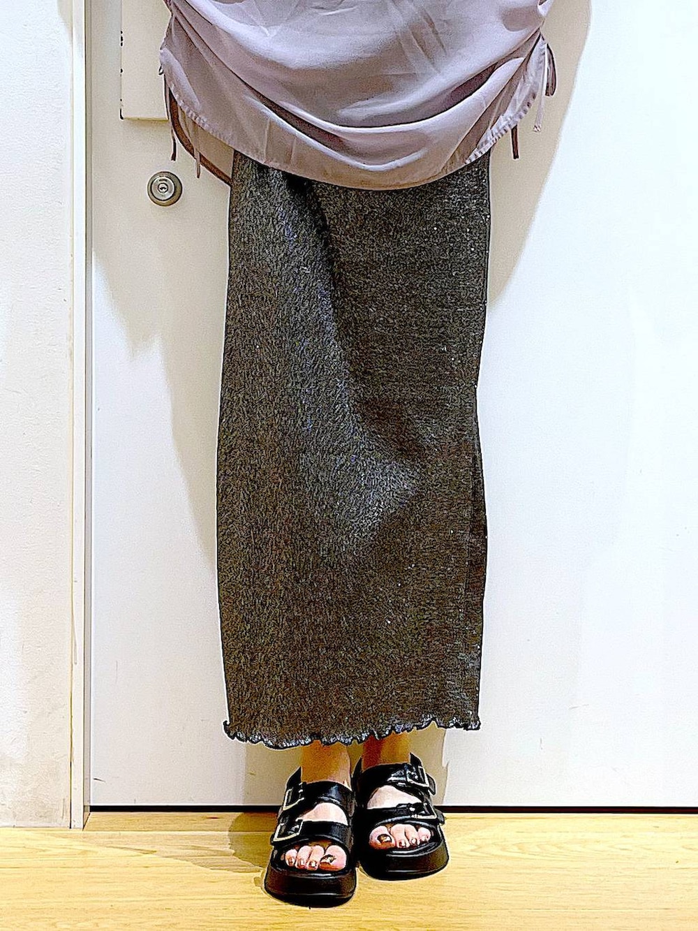 ブラック系のスカート、ブラック系のショルダーバッグ、ブラック系のサンダルを着用したレディースの夏コーディネートの8枚目の写真