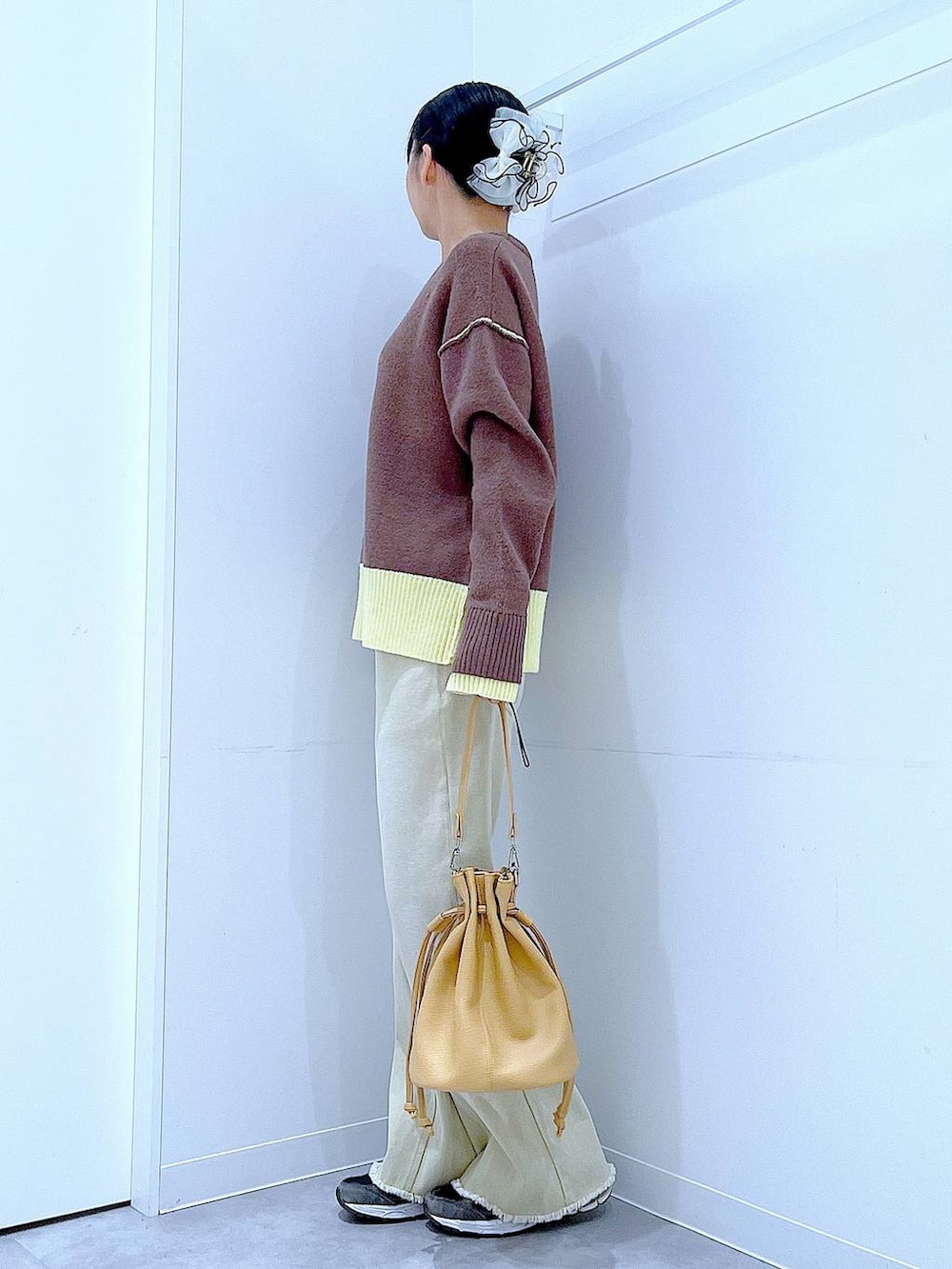 ブラウン系のニット/セーター、ベージュ系のデニムパンツ、ブラウン系のショルダーバッグを着用したレディースの冬コーディネートの3枚目の写真