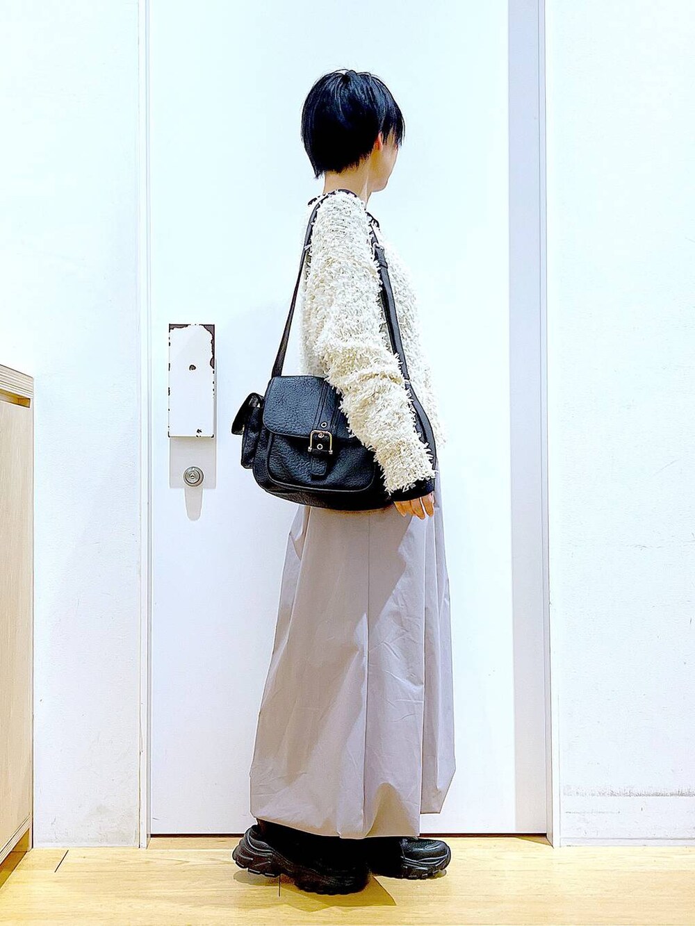 ブラック系のスニーカー、ブラック系のTシャツ/カットソー、グレー系のスカートを着用したレディースの春コーディネートの4枚目の写真