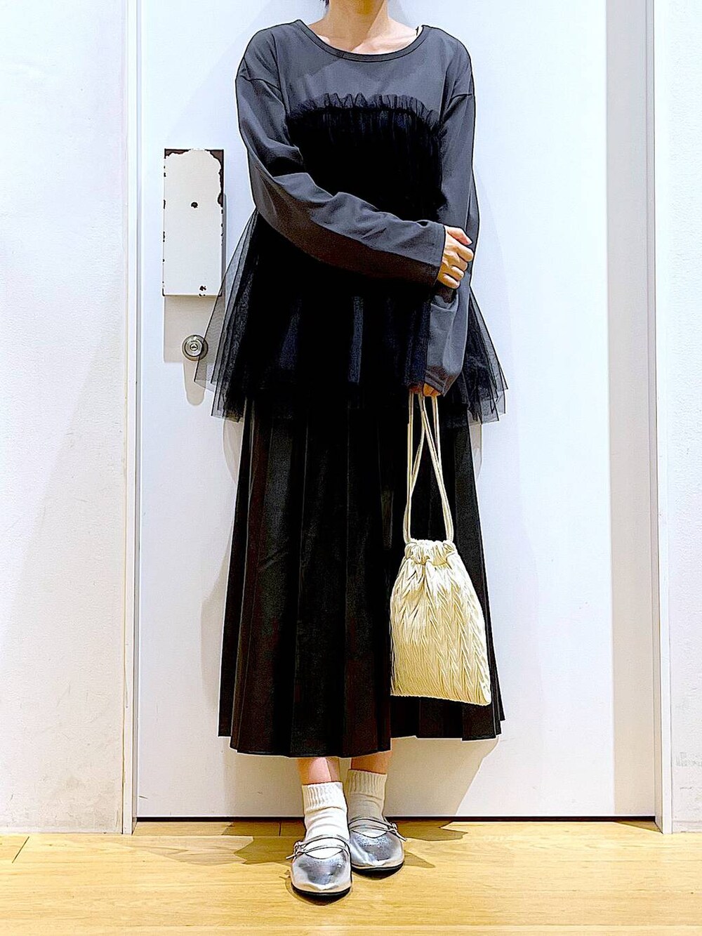 ホワイト系のショルダーバッグ、シルバー系のパンプス、ブラック系のスカートを着用したレディースの秋コーディネートの6枚目の写真