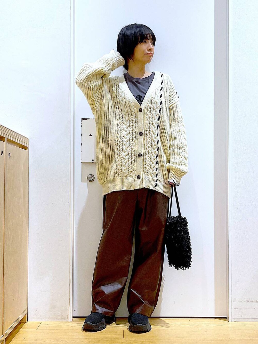 ブラック系のショルダーバッグ、グレー系のTシャツ/カットソー、ブラック系のブーツを着用したレディースの秋コーディネートの2枚目の写真