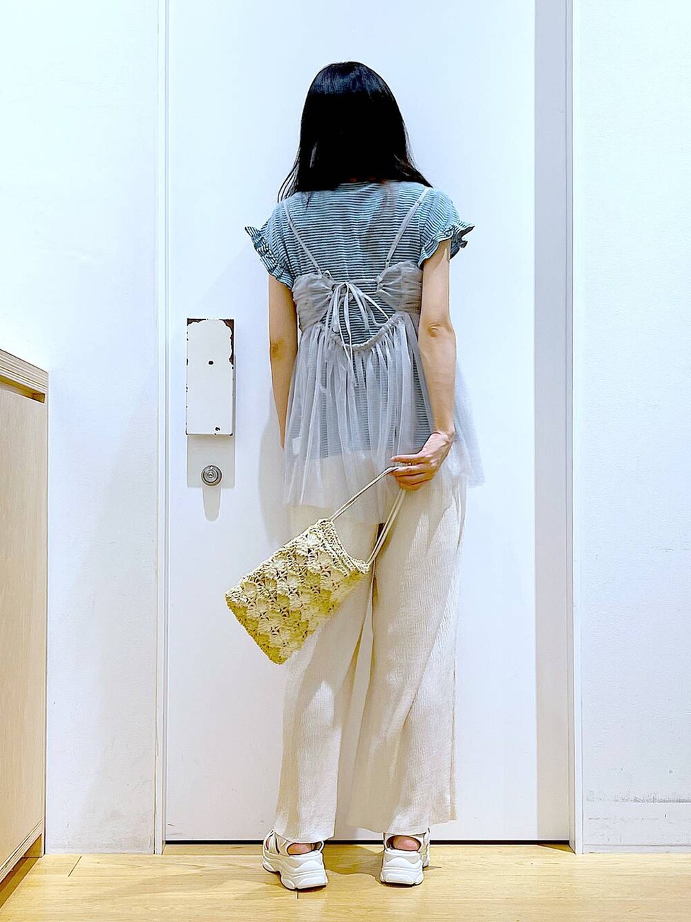 グレー系のキャミソール、ホワイト系のサンダル、ベージュ系のショルダーバッグを着用したレディースの夏コーディネートの5枚目の写真