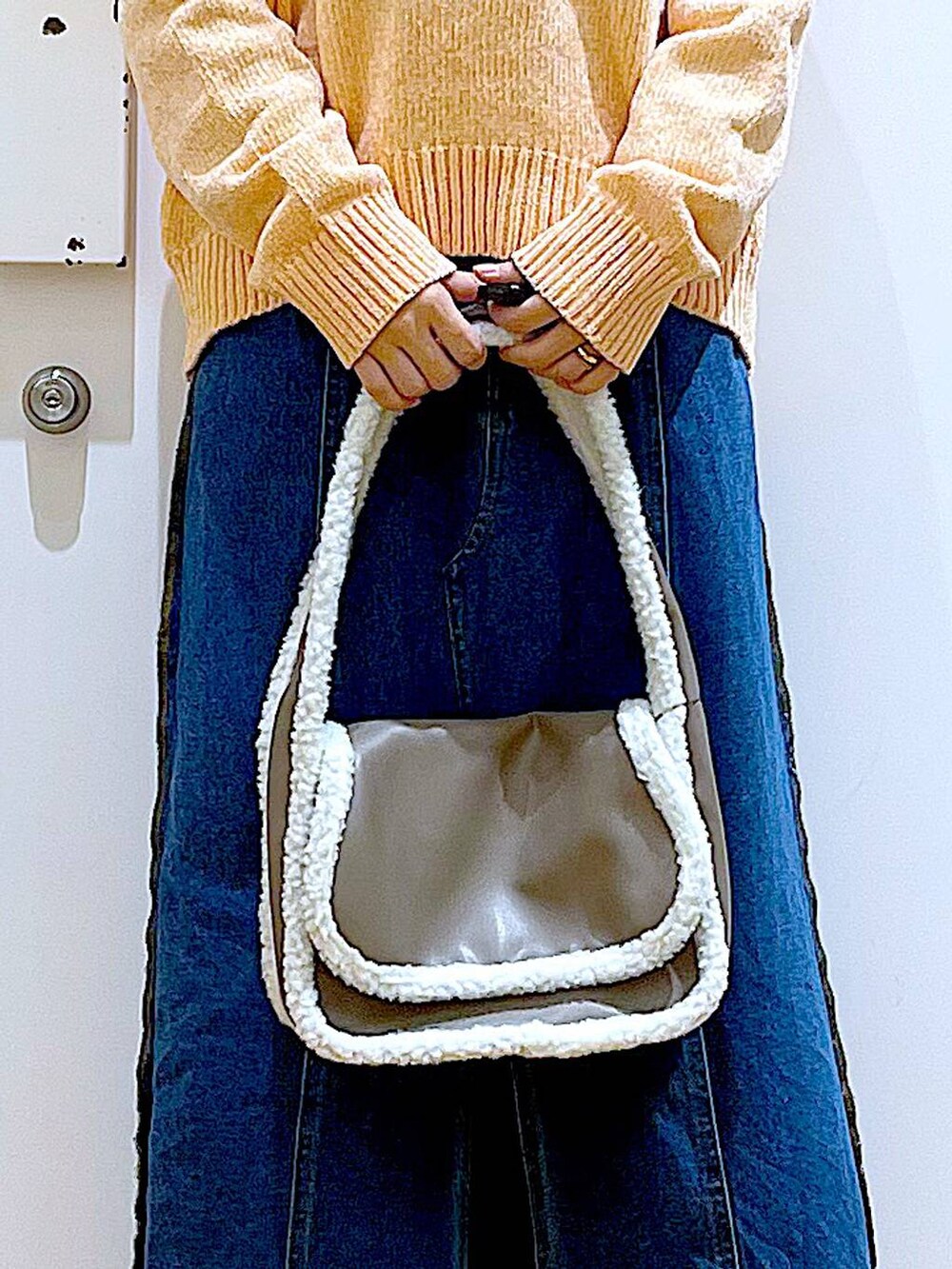 ブルー系のデニムスカート、ベージュ系のショルダーバッグ、ブラック系のブーツを着用したレディースの冬コーディネートの9枚目の写真