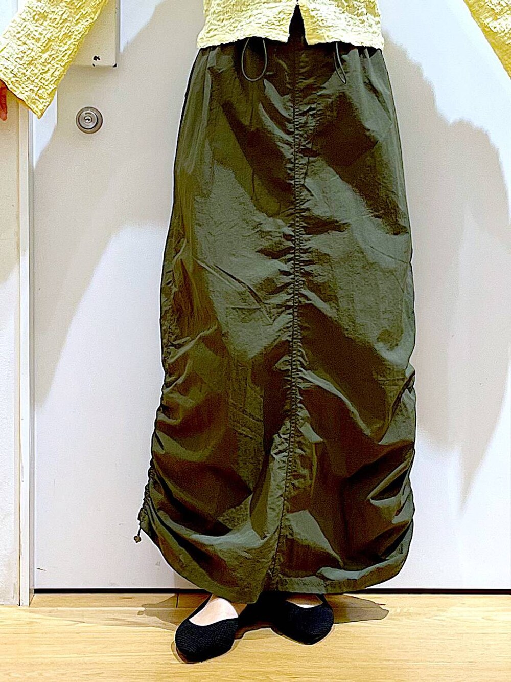 シルバー系のショルダーバッグ、グリーン系のスカート、ブラック系のパンプスを着用したレディースの春コーディネートの8枚目の写真