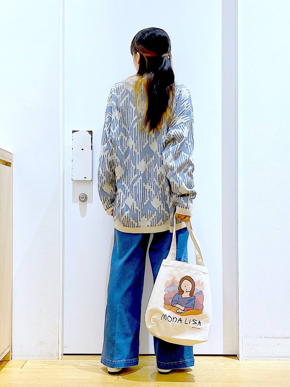 ブルー系のデニムパンツ、ベージュ系のカーディガン/ボレロ、その他のトートバッグを着用したレディースの春コーディネートの5枚目の写真