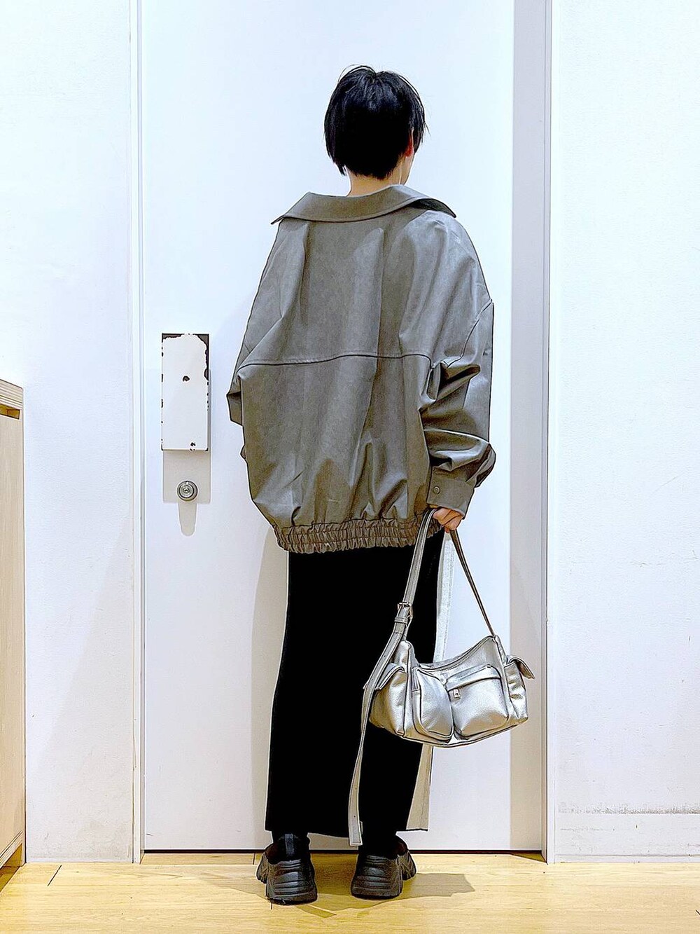 ブラック系のスカート、グレー系のブルゾン、ブラック系のブーツを着用したレディースの冬コーディネートの5枚目の写真