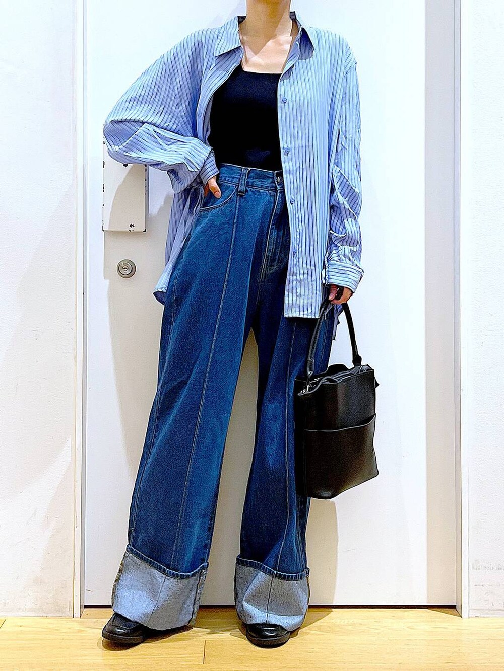 ブラック系のローファー、ブラック系のショルダーバッグ、ブルー系のシャツ/ブラウスを着用したレディースの秋コーディネートの6枚目の写真