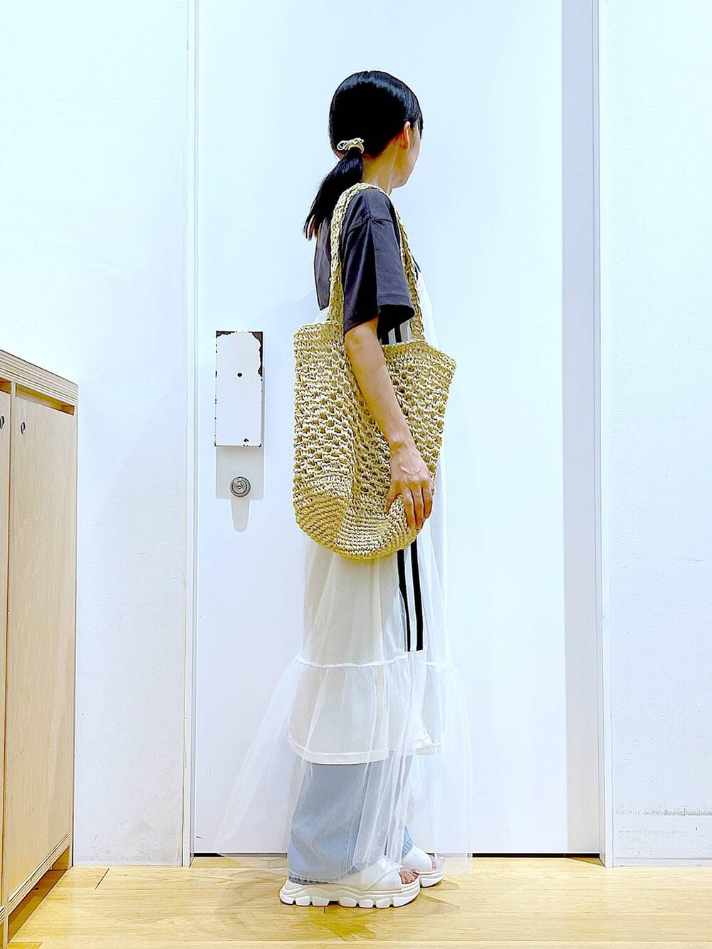 ホワイト系のサンダル、ブルー系のデニムパンツ、ホワイト系のトートバッグを着用したレディースの夏コーディネートの4枚目の写真