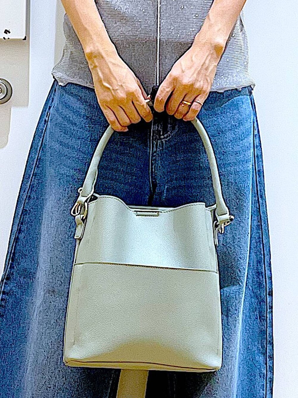 グレー系のTシャツ/カットソー、ブルー系のデニムパンツ、グリーン系のショルダーバッグを着用したレディースの秋コーディネートの9枚目の写真