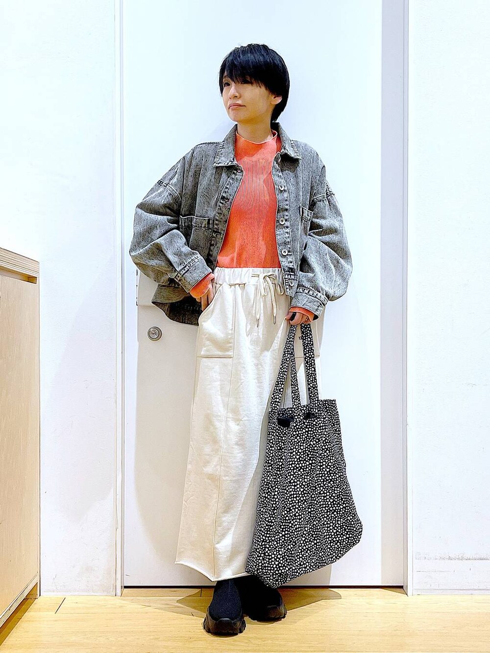 ブラック系のブーツ、その他のトートバッグ、ブラック系のデニムジャケットを着用したレディースの春コーディネートの2枚目の写真