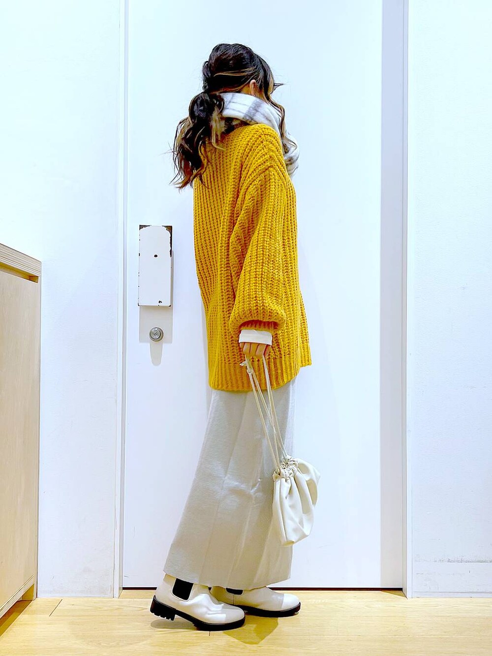 グレー系のスカート、ベージュ系のブーツ、ベージュ系のショルダーバッグを着用したレディースの冬コーディネートの4枚目の写真