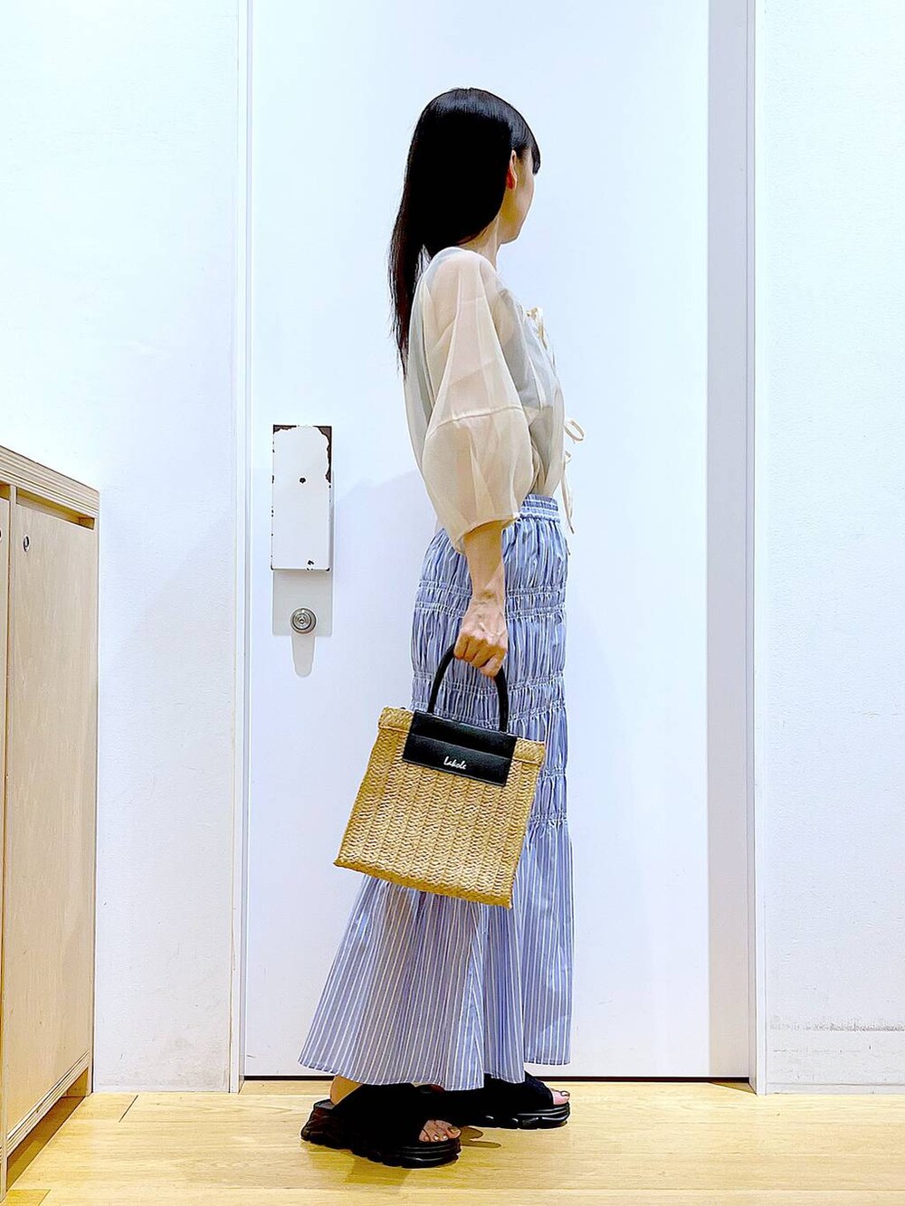 ブラック系のサンダル、その他のスカート、ブラック系のニット/セーターを着用したレディースの夏コーディネートの4枚目の写真